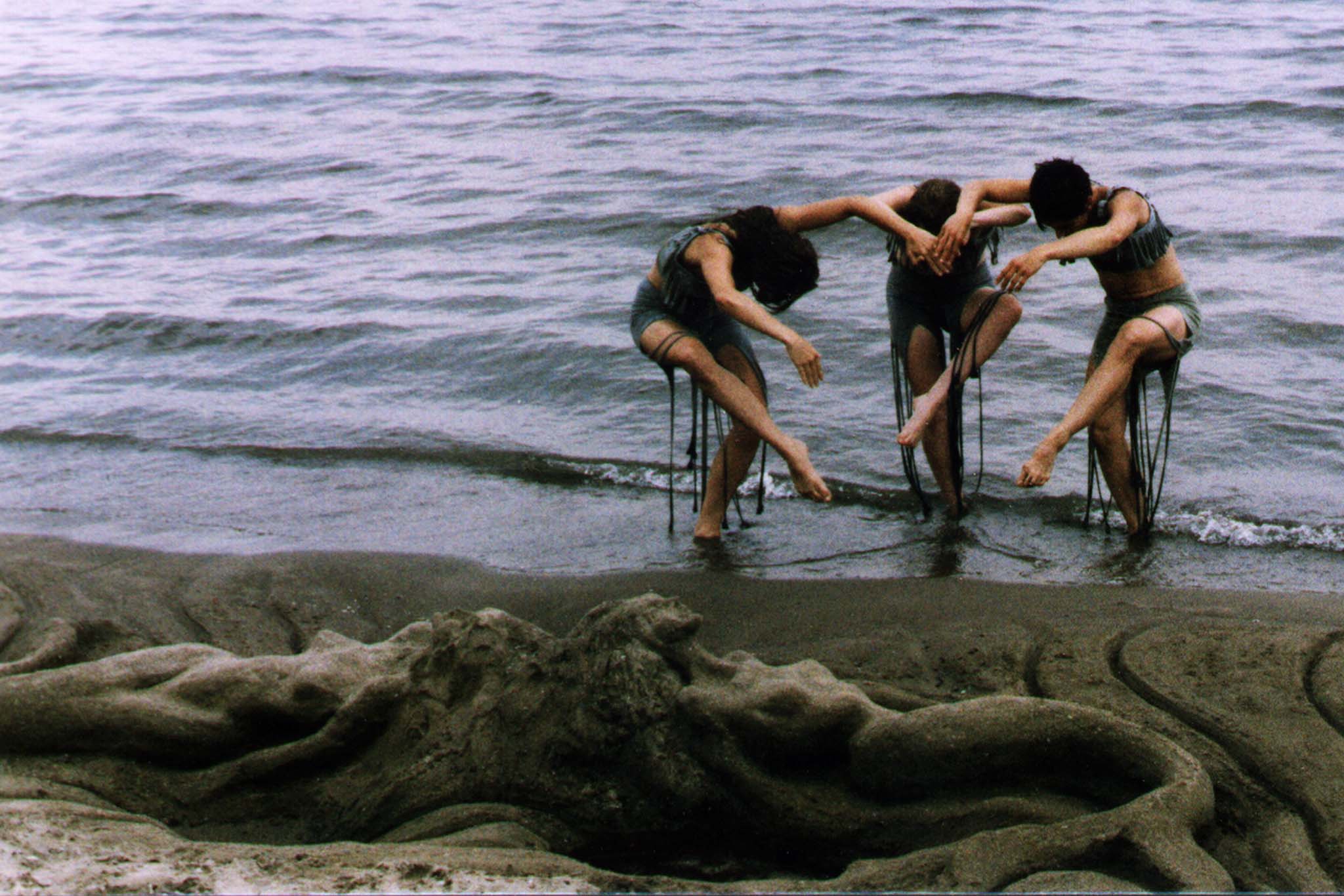 Image of 3 MorrisonDancers in front of a siren sand statue 