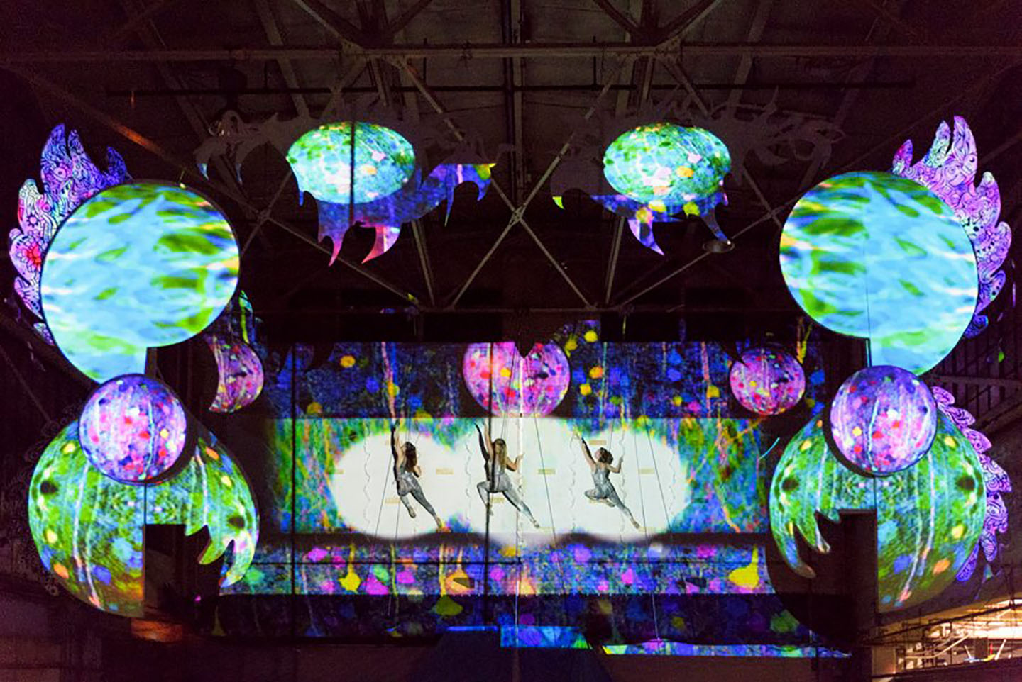 Image of 3 MorrisonDancers suspended from a colorful wall