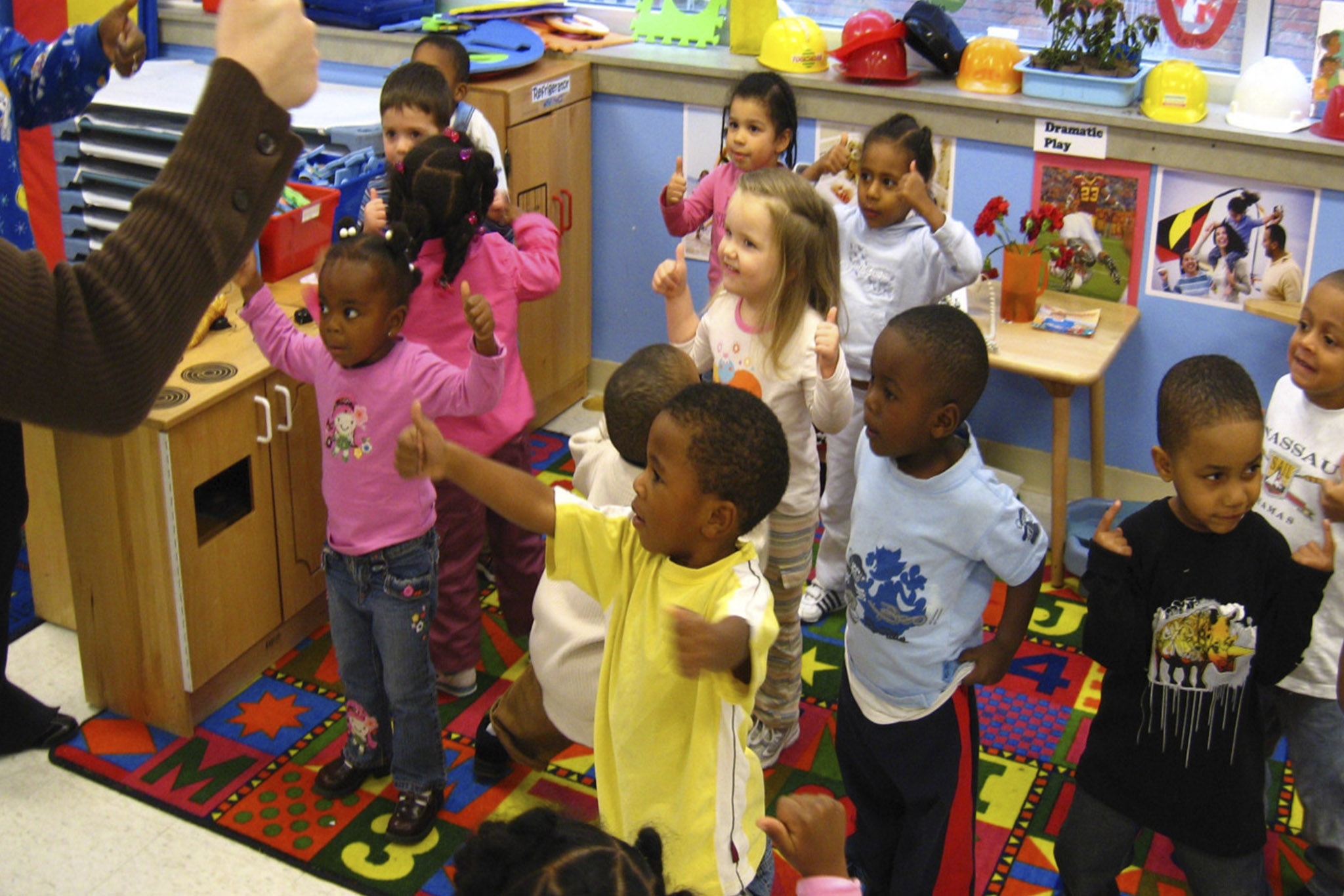 Image of a room full of children with their thumbs up